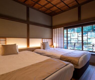 Twin beds in a Japanese-style room with shoji screens, wooden ceiling and garden view at Kamakura COCON, Kanagawa