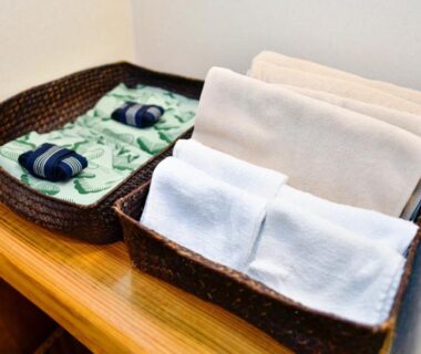 Wicker baskets with folded towels and cloth items on wooden shelf in ryokan