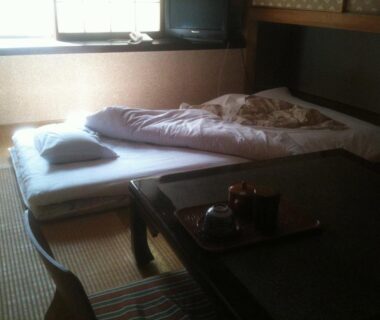 Futon on tatami beside low table with tea tray at Kamesei Ryokan in Nagano, Chūbu, Japan