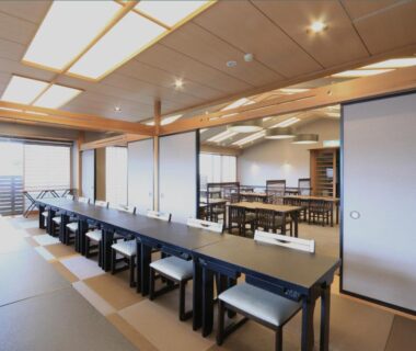 Long tatami dining room with low stools and shoji screens at Kameya Ean Shizuoka