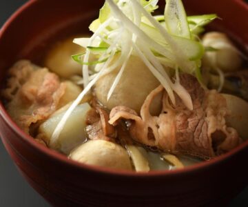Bowl of thinly sliced meat and vegetables in broth at Kami no yama Azumaya, Yamagata