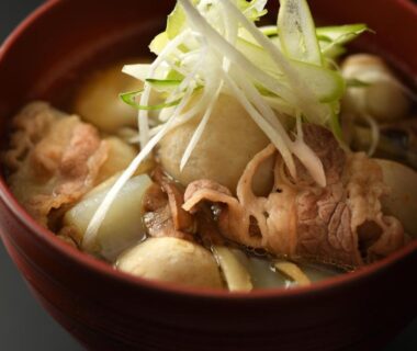 Bowl of thinly sliced meat and vegetables in broth at Kami no yama Azumaya, Yamagata