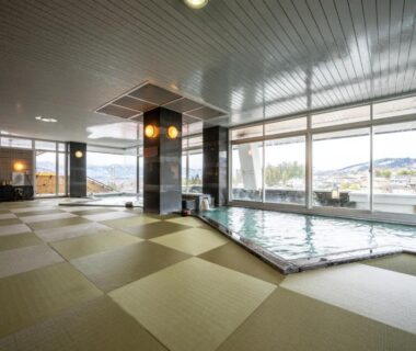 Spacious indoor onsen with tatami mat flooring and large windows at Kami no yama Azumaya, Yamagata