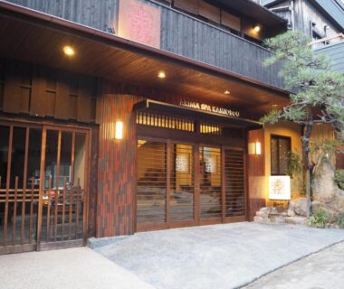 Entrance of Kamiobo Ryokan in Hyōgo with wooden facade, sliding doors and stone lantern