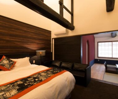 Interior with bed, tatami seating area and shoji screens at Kamishichiken Oku in Kyoto