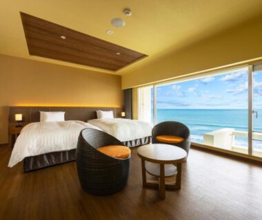 Twin beds and wicker seating overlooking the sea at Kamogawa Grand Hotel, Chiba