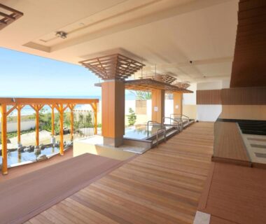 Covered wooden terrace with baths and pergola overlooking distant horizon at Kamogawa Grand Hotel Chiba