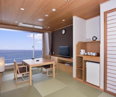 Tatami room with low table, shoji screen and large window overlooking the sea at Kamogawa Grand Hotel, Chiba