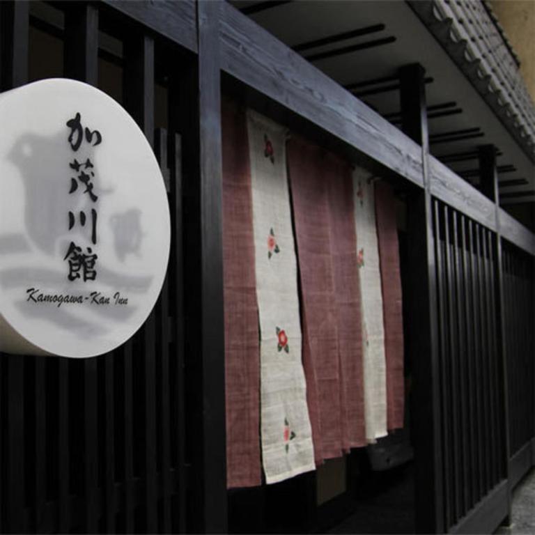 Noren and wooden lattice at Kamogawakan Kyoto Round kanji sign and noren at Kamogawakan entrance in Kyoto