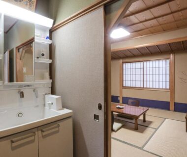 Tatami room with low table and sink area at Kamuroan Kyoto