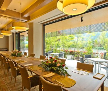Indoor dining room with long wooden table and garden terrace at Kanaya Hotel Kinugawa, Tochigi