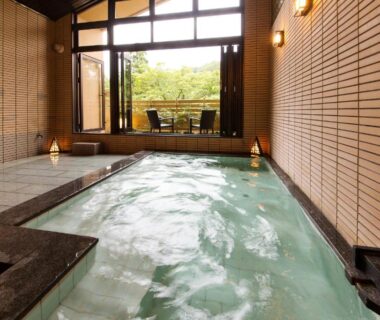 Indoor onsen bath with bubbling water at Kanazawa Hyakurakusou in Ishikawa, open window and balcony seating