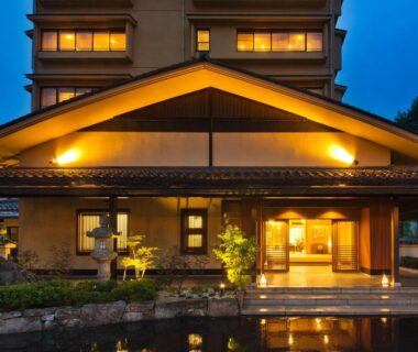 Lit ryokan entrance with reflecting pond at dusk Kanazawa Hyakurakusou Ishikawa