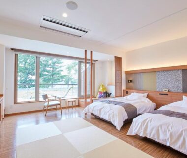 Spacious tatami-style room with twin beds, seating area and garden view at Kangetsuen, Hokkaido