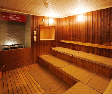 Interior wood-paneled sauna with tiered bench seats and cushions at Kangetsuen in Hokkaidō