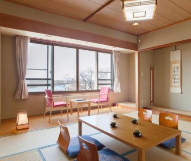 Tatami room with low table, zaisu chairs, tokonoma alcove and window seating at Kangetsuen Hokkaidō