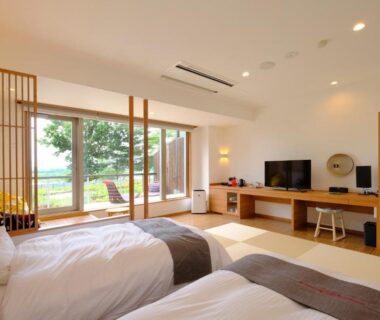 Bright tatami room with twin beds, shoji screens and garden view at Kangetsuen in Hokkaidō