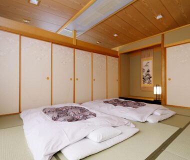 Traditional tatami room with two futons, shoji screens and tokonoma alcove at Kanko Hotel Tamaru, Nara