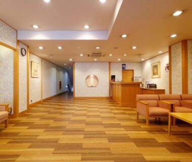 Warm reception lobby with wooden flooring, sofas and desk at Kanko Hotel Tamaru in Nara