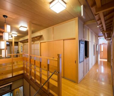 Wooden corridor with sliding doors, staircase and pendant lights at Kanko Ryokan Kuboji, Nara, Kansai, Japan