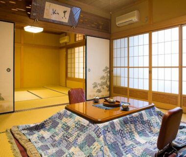 Tatami room with kotatsu table and shoji screens at Kanko Ryokan Kuboji in Nara, Kansai