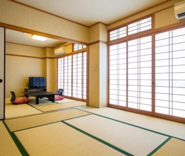 Spacious tatami room with low table, zabuton cushions and shoji screens at Kannawa Yunoka in Ōita