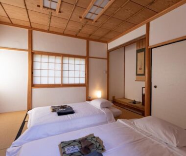 Tatami room with futon bedding, shoji screens, wooden ceiling and alcove at Kannawaen in Ōita, Kyūshū