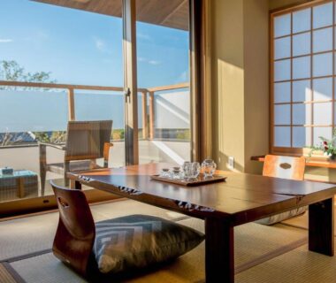 Traditional tatami room with low table, zabuton cushion, shoji screens and sunlit balcony at Kannawaen, Ōita