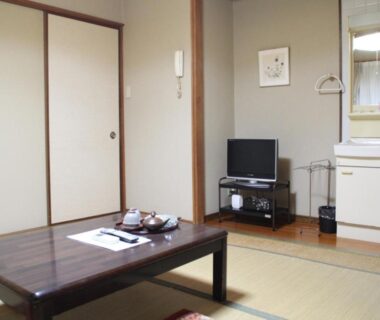 Tatami room with low table, tea set, sliding doors and small TV at Kannawaso in Ōita, Kyushu