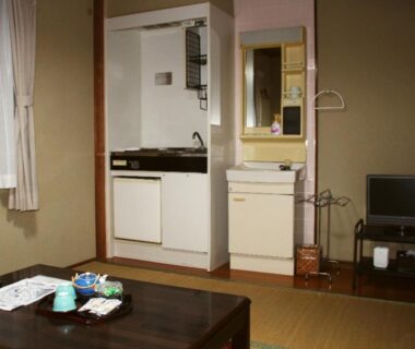 Tatami room with low table, kitchenette and TV at Kannawaso in Ōita, Kyushu