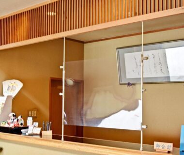 Reception desk with wooden slats and clear divider at Kanoe Ryokan in Nagano, Chubu, Japan