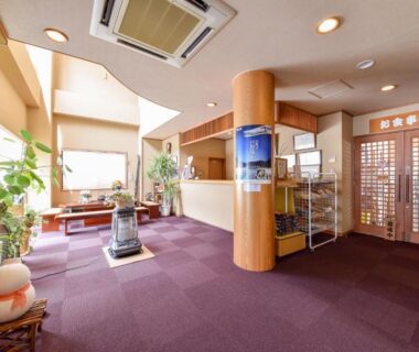 Ryokan lobby seating area with shoji doors and potted plants at Kanoe in Nagano