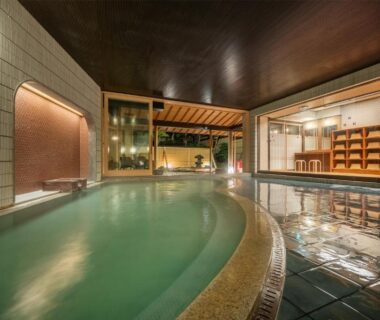 Spacious indoor onsen bath with tiled floor and wooden ceiling at Kansyokan, Yamagata