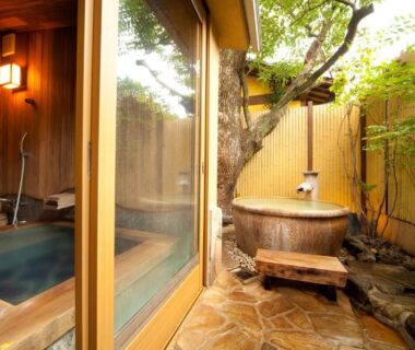 Enclosed courtyard with wooden outdoor tub and indoor soaking bath visible through sliding glass doors