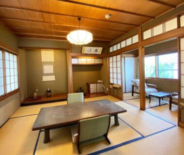 Traditional tatami room with low table, zaisu chairs, shoji screens and tokonoma at Kappo Ryokan Yumesaki in Ōita, Kyūshū