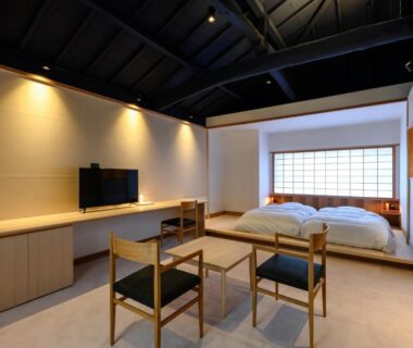 Spacious tatami-style room with twin futons, shoji screen, low table, chairs and wall-mounted TV