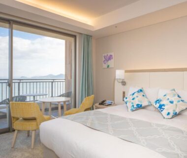 Double bed room with balcony, table and chairs, sliding doors opening to sea view at Karatsu Seaside Hotel, Saga