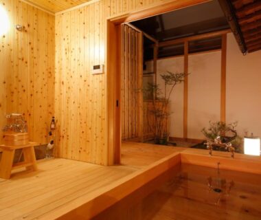 Wooden indoor soaking bath with sliding screen and plants at Kariya Ryokan Q, Hyōgo