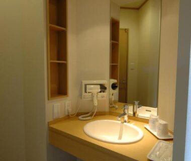 Wooden vanity with round sink, mirror and stool at Karurusu Onsen Yumoto Orofuresou, Hokkaido