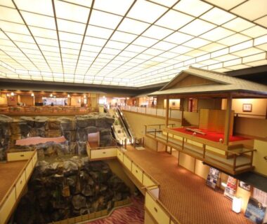 Interior atrium with central rock water feature, wooden walkways and traditional Japanese architectural details at Kashikojima Hojoen in Mie