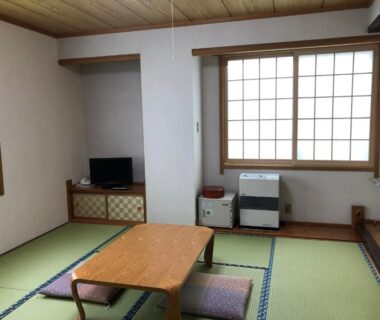 Traditional tatami room with low table, shoji screens, cushions and heater at Kashiwaya Gassan Yamagata