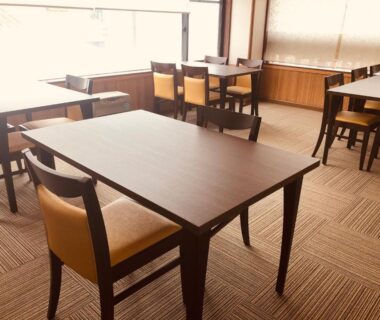Spacious dining area with wooden tables, upholstered chairs and carpeted floor at Kashiwaya Gassan in Yamagata