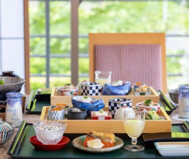 Assorted small dishes on low table with shoji screens and garden view at Kashoen Iwate