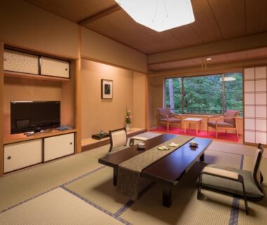 Tatami room with low table, zabuton seating and shoji screens overlooking garden at Kashoen in Iwate Tōhoku