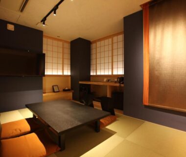 Tatami room with low table, cushions, shoji screens and warm lighting at Kashoutei Hanaya in Hokkaidō