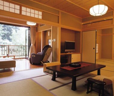 Tatami room with low table, shoji screens, balcony and massage chair at Kasuga Hotel Nara