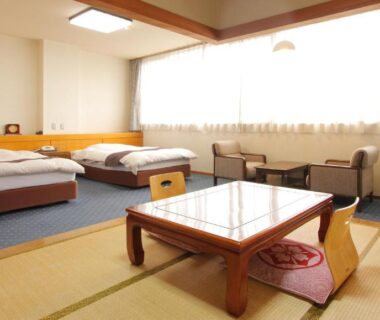 Tatami area with low table and twin beds at Kasugai View Hotel, Yamanashi