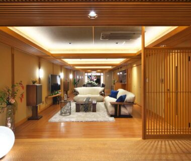 Spacious wooden lounge with low seating, shoji screens and soft lighting at Kasuitei Ooya in Yamanashi