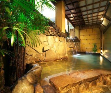 Indoor stone onsen bath with rock spouts and wooden ceiling at Kasuitei Ooya, Yamanashi Chubu Japan
