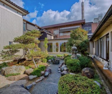 Courtyard garden with stone lantern, gravel path and trimmed pines at Katsuzakikan in Ishikawa, Chūbu